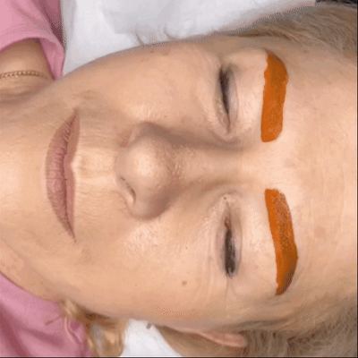 movimento di una cliente con una maschera di pigmento rosso che copre le sopracciglia per riscaldare il colore movimento di una cliente con una maschera di pigmento rosso che copre le sopracciglia per riscaldare il colore